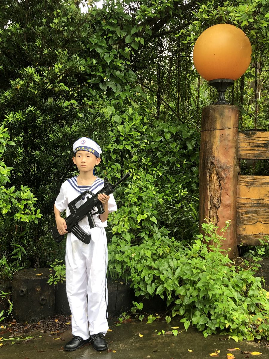 绿植旁持枪留影